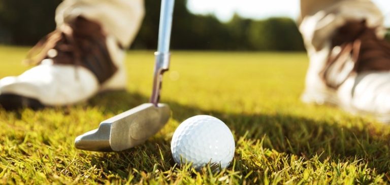storyblocks close up of male golfer teeing off while standing on golf course H0MdEY2T9W